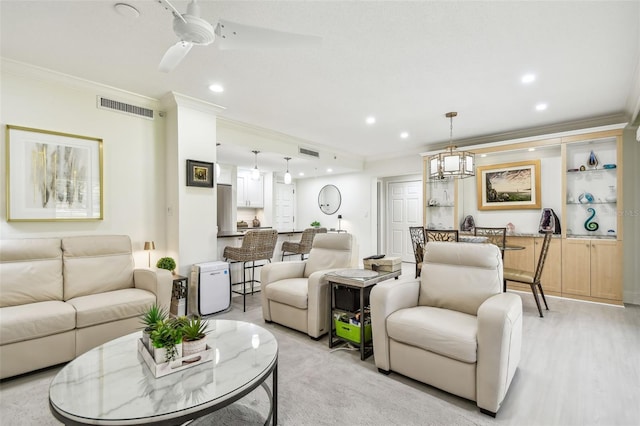 living area featuring recessed lighting, visible vents, a ceiling fan, and ornamental molding