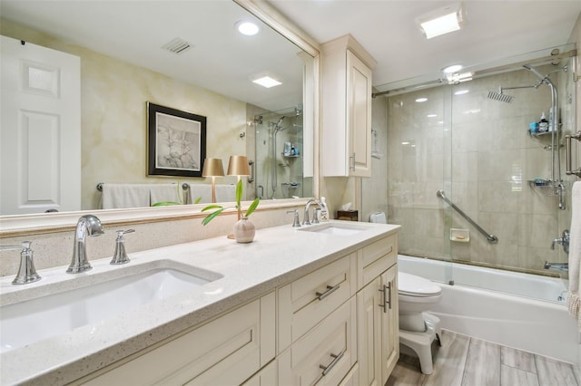 bathroom with toilet, double vanity, visible vents, and a sink