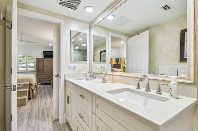 bathroom with wood finished floors, a sink, and visible vents