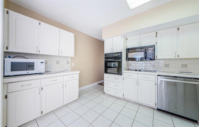 kitchen with light tile patterned floors, tasteful backsplash, white cabinetry, and black appliances