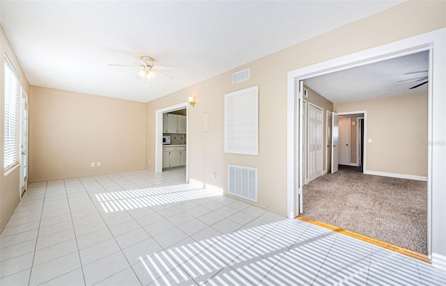 unfurnished room featuring ceiling fan and light carpet