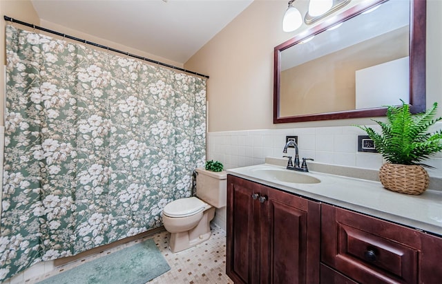 bathroom featuring tile patterned flooring, vanity, tile walls, and toilet