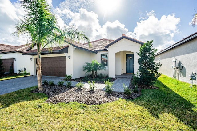 mediterranean / spanish-style house featuring a garage and a front yard