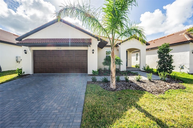 view of front of home with a garage and a front lawn