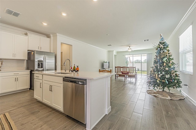 kitchen featuring white cabinetry, appliances with stainless steel finishes, and an island with sink