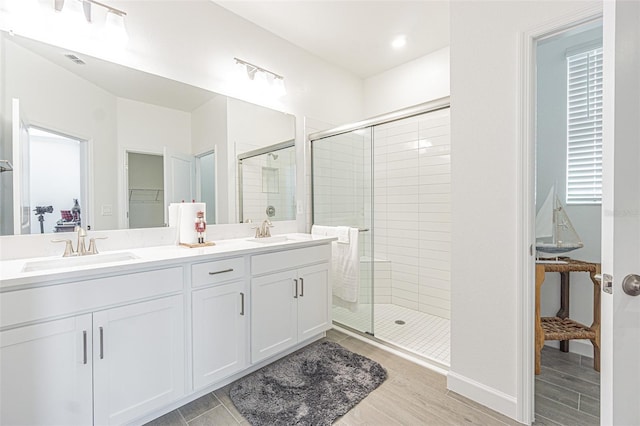 bathroom with an enclosed shower, vanity, and hardwood / wood-style floors