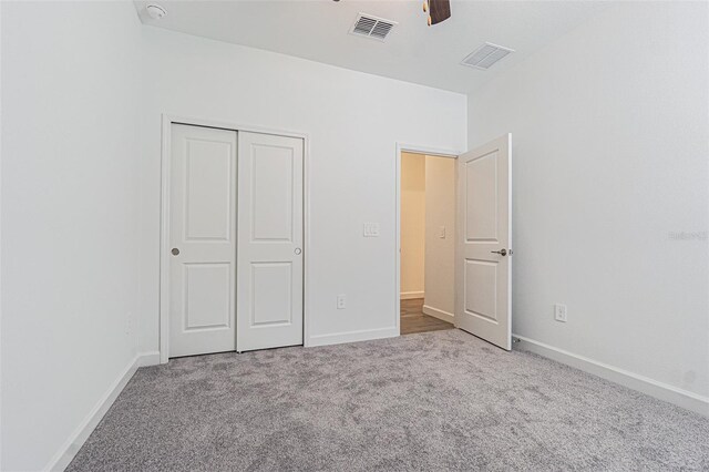 unfurnished bedroom with ceiling fan, a closet, and light carpet