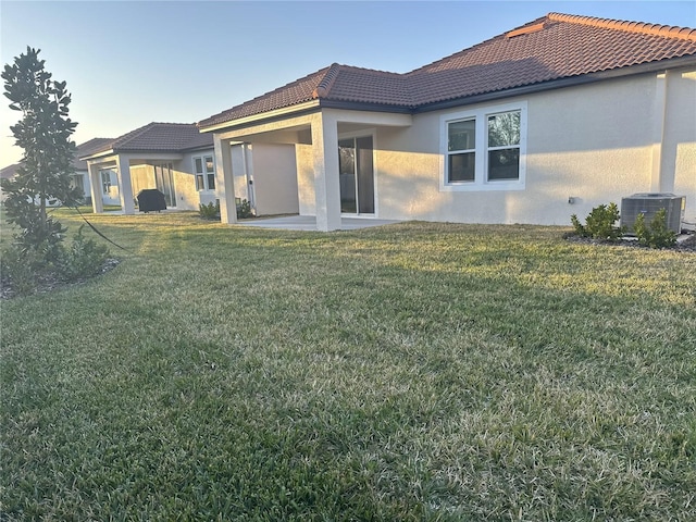 back of property featuring a yard, a patio, and central air condition unit