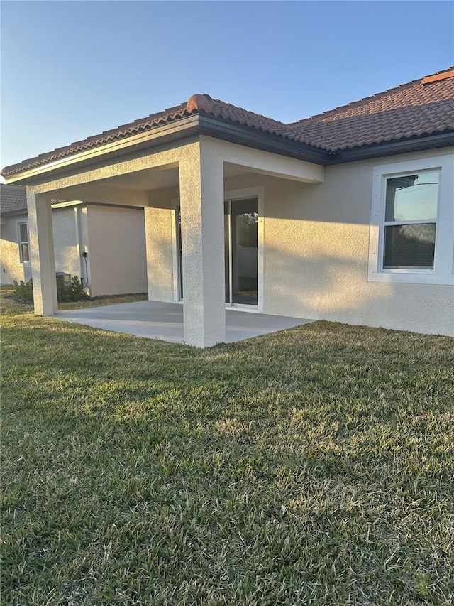 rear view of property with a lawn and a patio