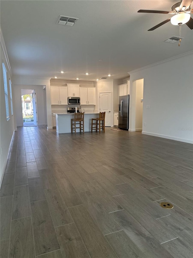 unfurnished living room featuring ornamental molding and ceiling fan