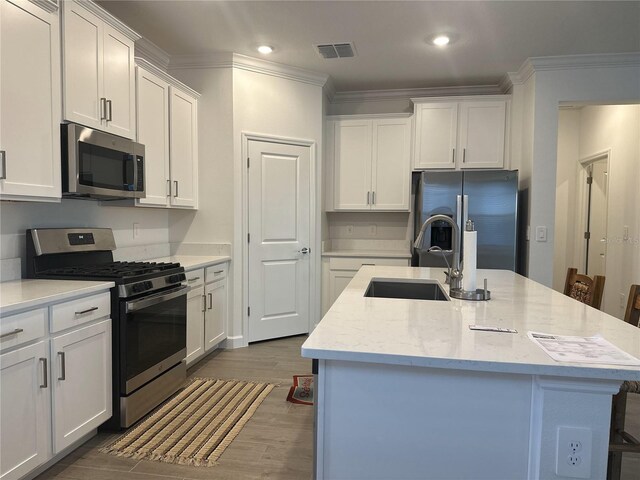 kitchen with white cabinetry, sink, a center island with sink, and appliances with stainless steel finishes