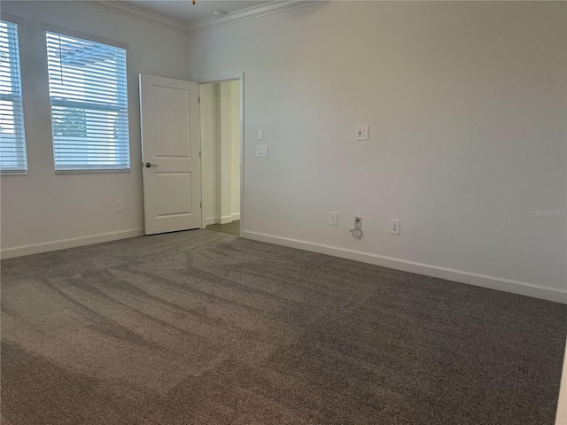 carpeted spare room featuring crown molding