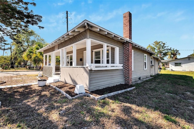 view of side of home featuring a yard and a porch