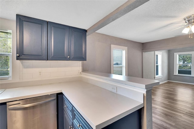 kitchen featuring dishwasher, a healthy amount of sunlight, kitchen peninsula, and blue cabinetry