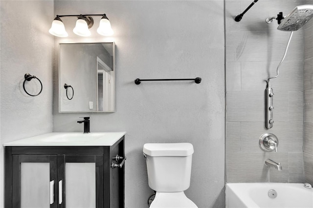 full bathroom featuring vanity, tiled shower / bath combo, and toilet