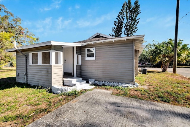 view of front of house with cooling unit and a front yard