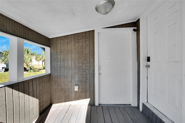 bathroom with hardwood / wood-style flooring, a textured ceiling, wooden walls, and vaulted ceiling