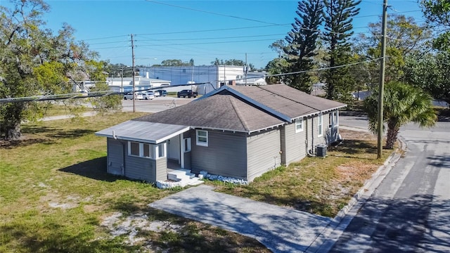 view of property exterior with a lawn and cooling unit