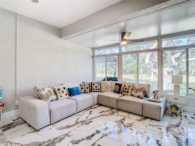 living room with ceiling fan and a wall of windows