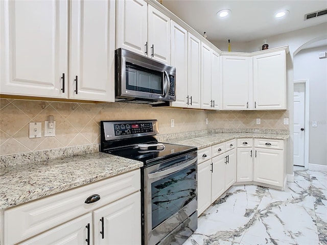 kitchen with backsplash, white cabinetry, light stone counters, and appliances with stainless steel finishes