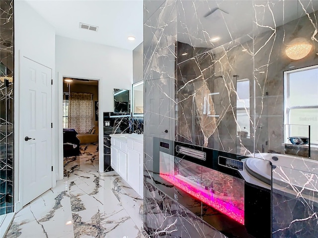 bathroom featuring vanity and tile walls