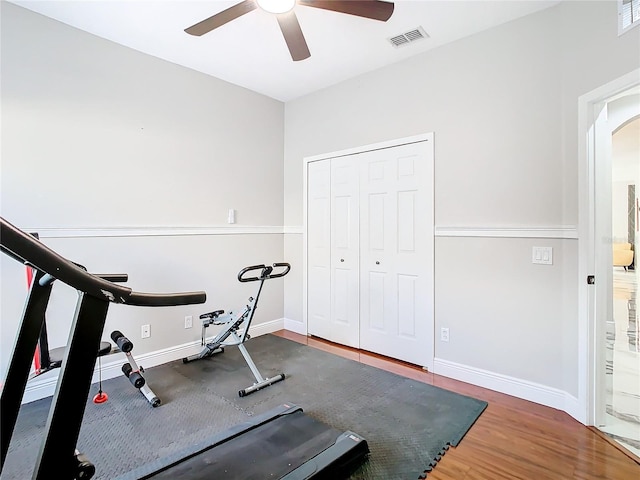 workout area with dark hardwood / wood-style floors and ceiling fan