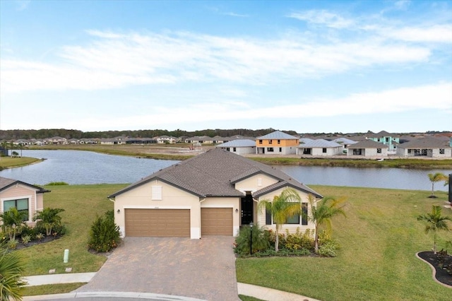 ranch-style home with a water view, a garage, and a front lawn