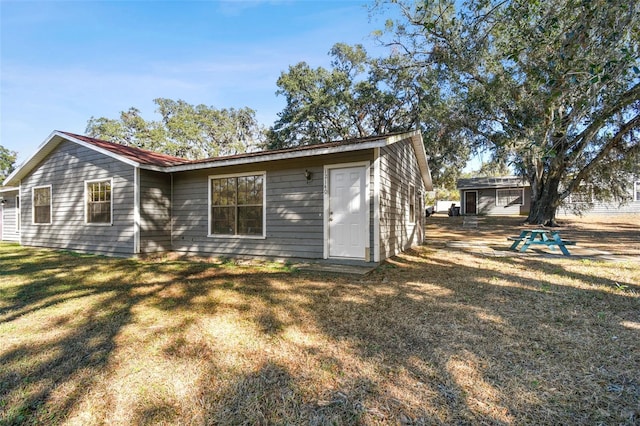 back of house featuring a lawn