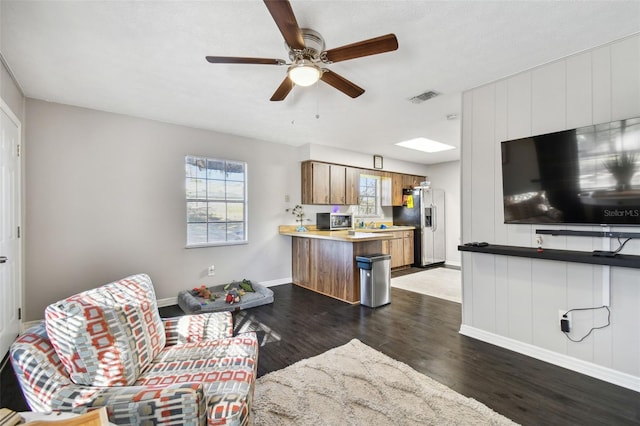 living room with ceiling fan and dark hardwood / wood-style flooring