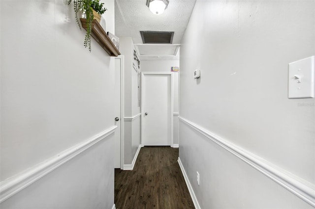 hallway featuring a textured ceiling and dark hardwood / wood-style flooring