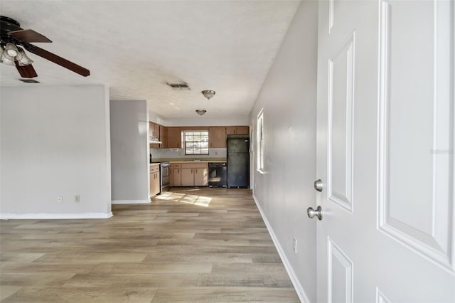 unfurnished living room with a textured ceiling, light hardwood / wood-style flooring, and ceiling fan