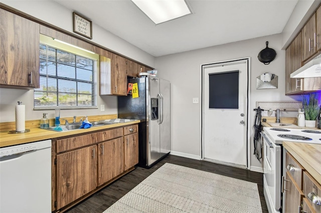 kitchen featuring sink, dark wood-type flooring, and white appliances