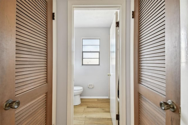 bathroom with hardwood / wood-style flooring, toilet, and a textured ceiling