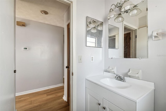 bathroom with hardwood / wood-style floors, vanity, and a textured ceiling