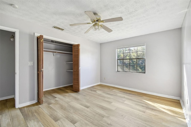 unfurnished bedroom featuring ceiling fan, a textured ceiling, and light wood-type flooring