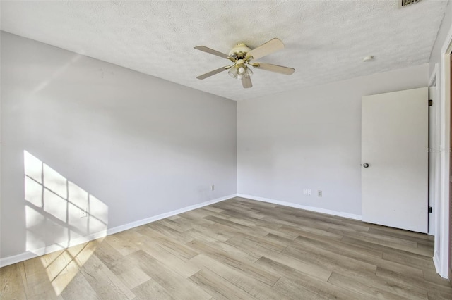 spare room with a textured ceiling, light wood-type flooring, and ceiling fan