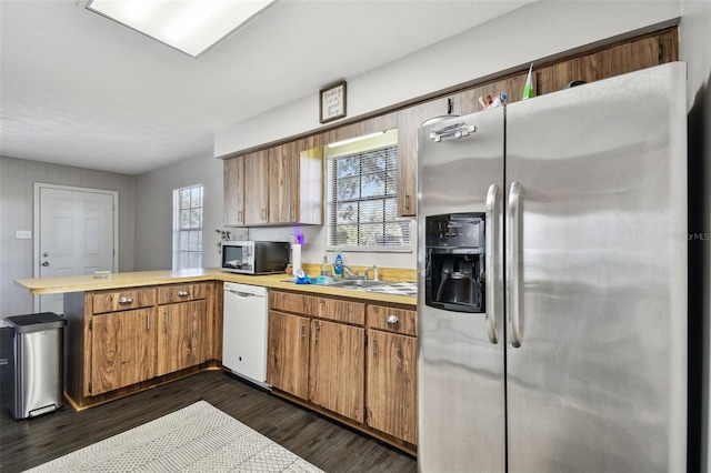 kitchen featuring kitchen peninsula, sink, dark hardwood / wood-style flooring, and appliances with stainless steel finishes