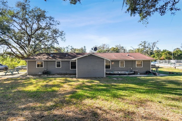 rear view of house with a yard and cooling unit