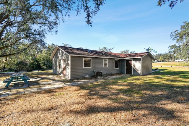 rear view of house with a lawn, a patio, and central AC unit