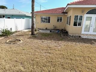 back of property with a yard and french doors