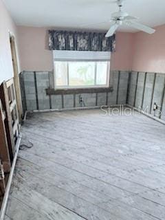 spare room with ceiling fan and light wood-type flooring