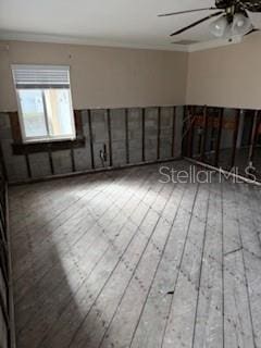 unfurnished room with hardwood / wood-style flooring, ceiling fan, and crown molding