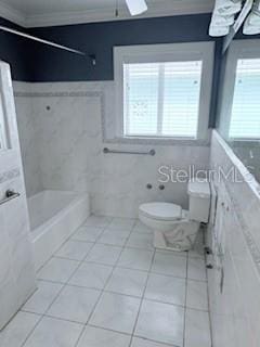 bathroom featuring tile patterned floors, tile walls, and a healthy amount of sunlight