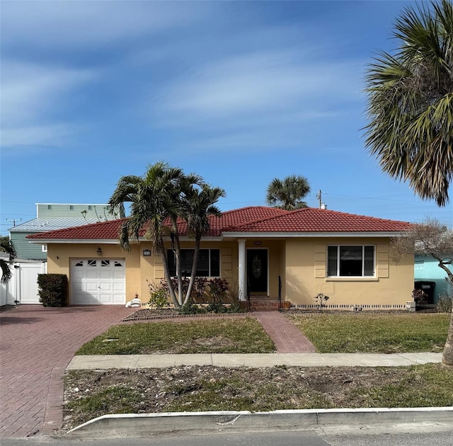 ranch-style home featuring a tiled roof, decorative driveway, an attached garage, and stucco siding