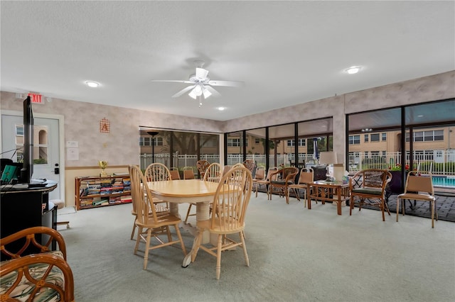 carpeted dining room with ceiling fan, plenty of natural light, and a textured ceiling