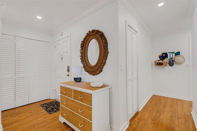 hall with light hardwood / wood-style flooring and ornamental molding