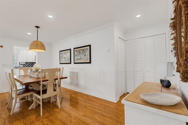 dining area featuring light hardwood / wood-style floors and crown molding