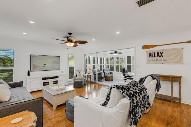 living room with light hardwood / wood-style flooring and ornamental molding