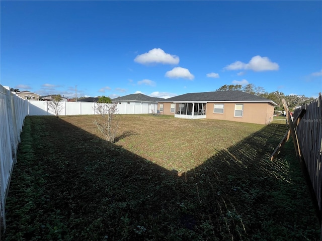 rear view of property with a sunroom and a yard