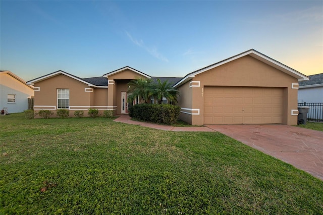 ranch-style house featuring a front yard, driveway, an attached garage, and stucco siding